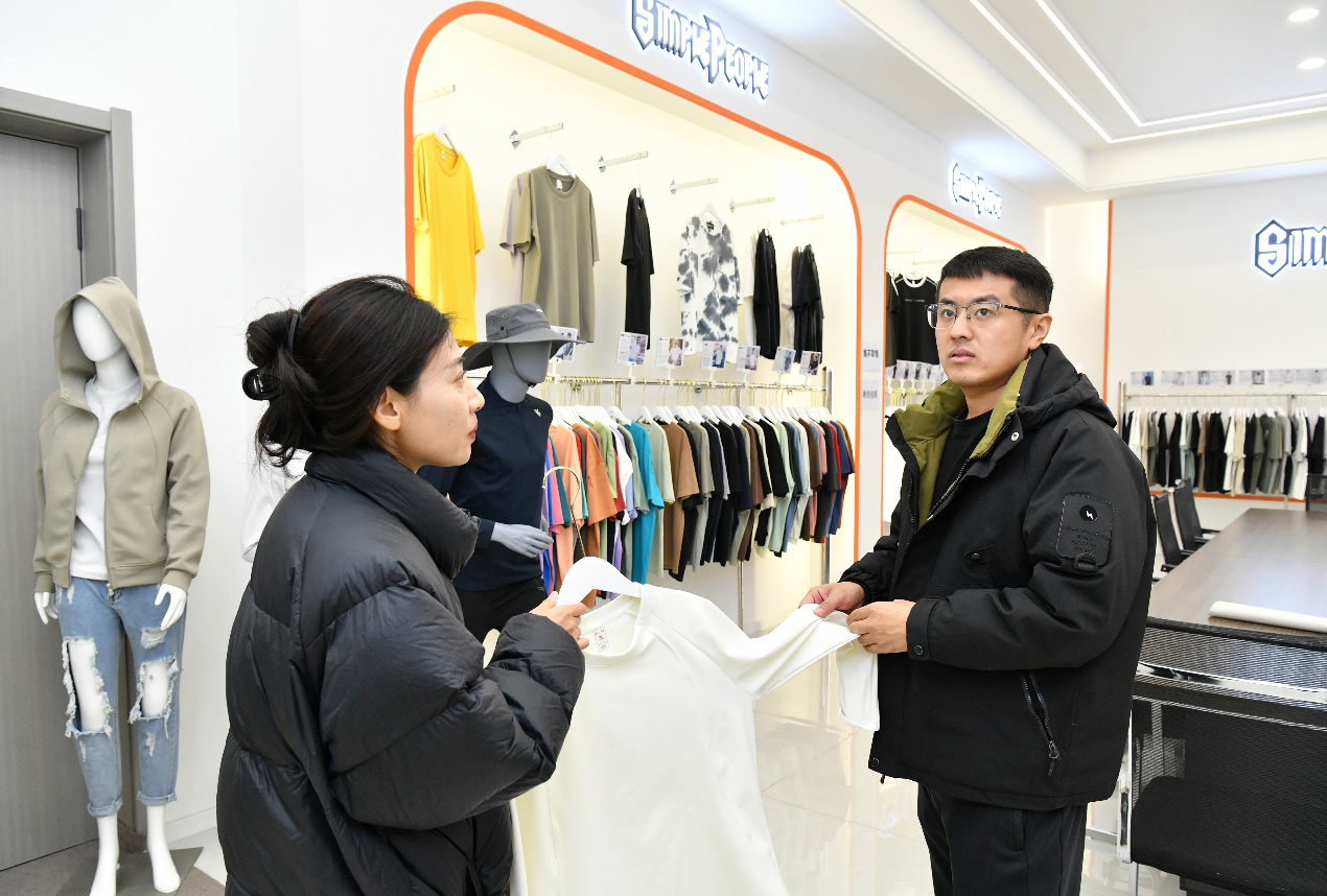 10月22日，客商（右）在肃宁县一家针纺服装企业展品室挑选商品。苑立伟摄