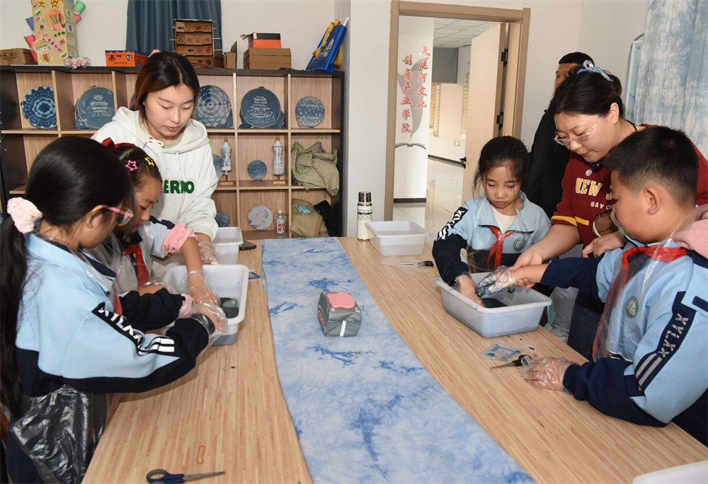 学校老师指导学生制作扎染布料。胡祝源摄