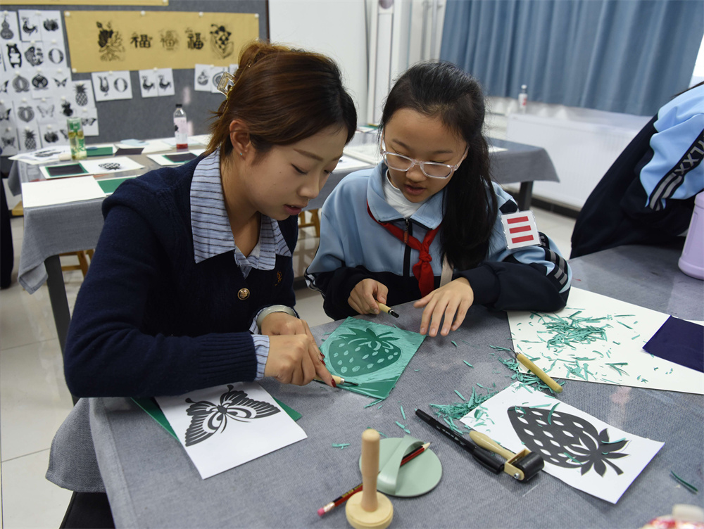 幼儿师范高等专科学校志愿者与学生一起制作麻胶版画。胡祝源