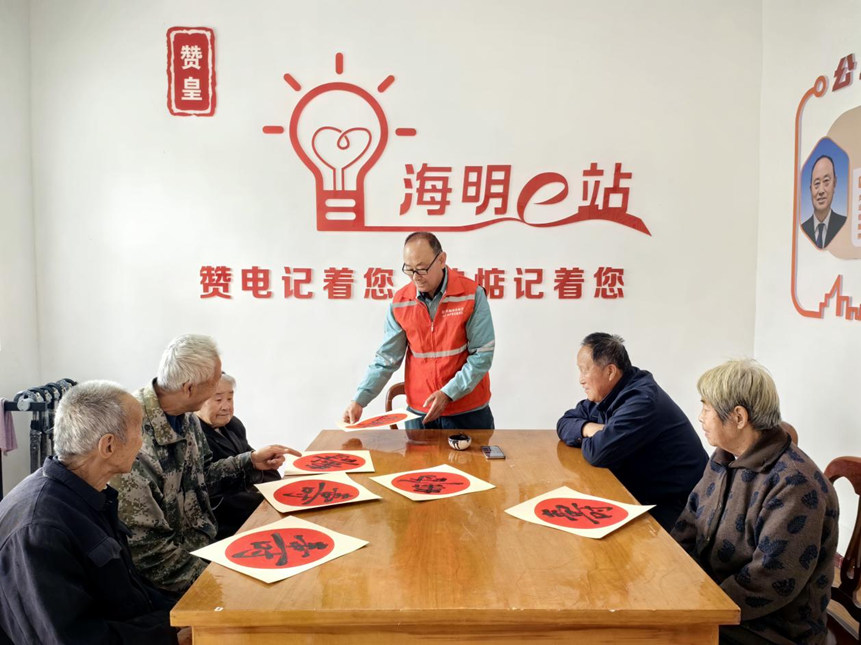 國網贊皇縣供電公司志願服務隊員在鬆會村“海明e站”開展“寫壽字、送祝福”重陽節主題活動。王一蘭攝