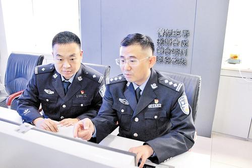 10月30日，許俊富（右）與同事在分析案情。 本報記者 桑珊攝