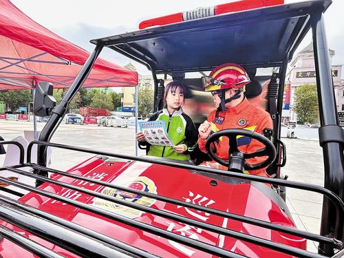 10月18日，河北省“雙爭有我 文明新風匯”群眾性精神文明創建活動圖片巡展首站在辛集市工人文化宮廣場舉行。這是消防隊員為小朋友講解消防知識。 本報記者 張曉超攝