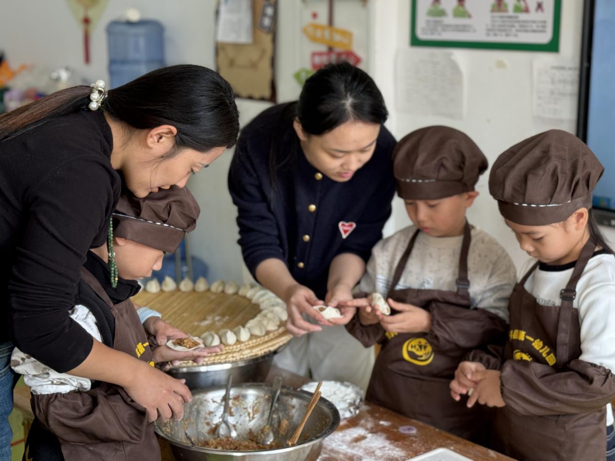 家长志愿者和孩子们一起包饺子。马荣丽摄
