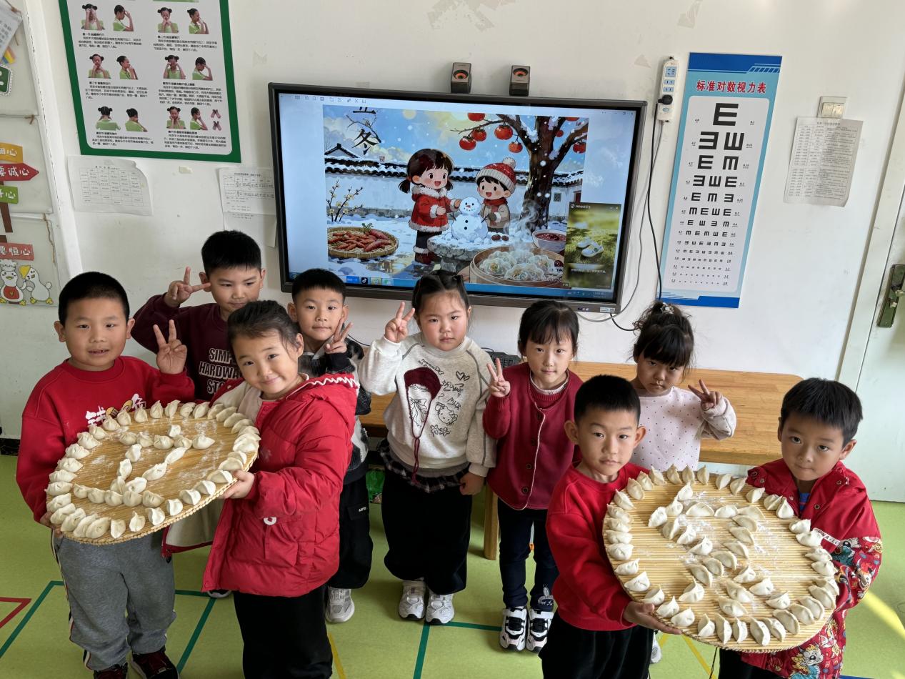 孩子们端着自己包好的饺子，脸上满是喜悦。马荣丽摄