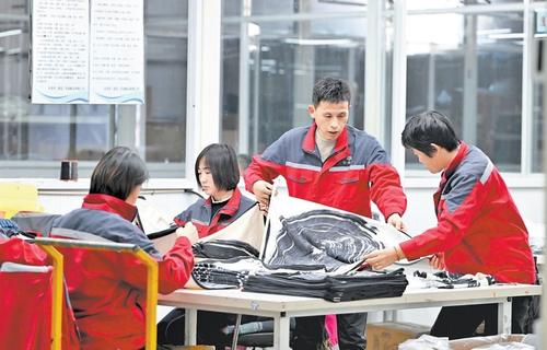 11月14日,安美橋(南宮)羊絨制品有限公司首席質量官趙建軍(右二)在檢查羊絨圍巾質量。本報記者 趙永輝攝