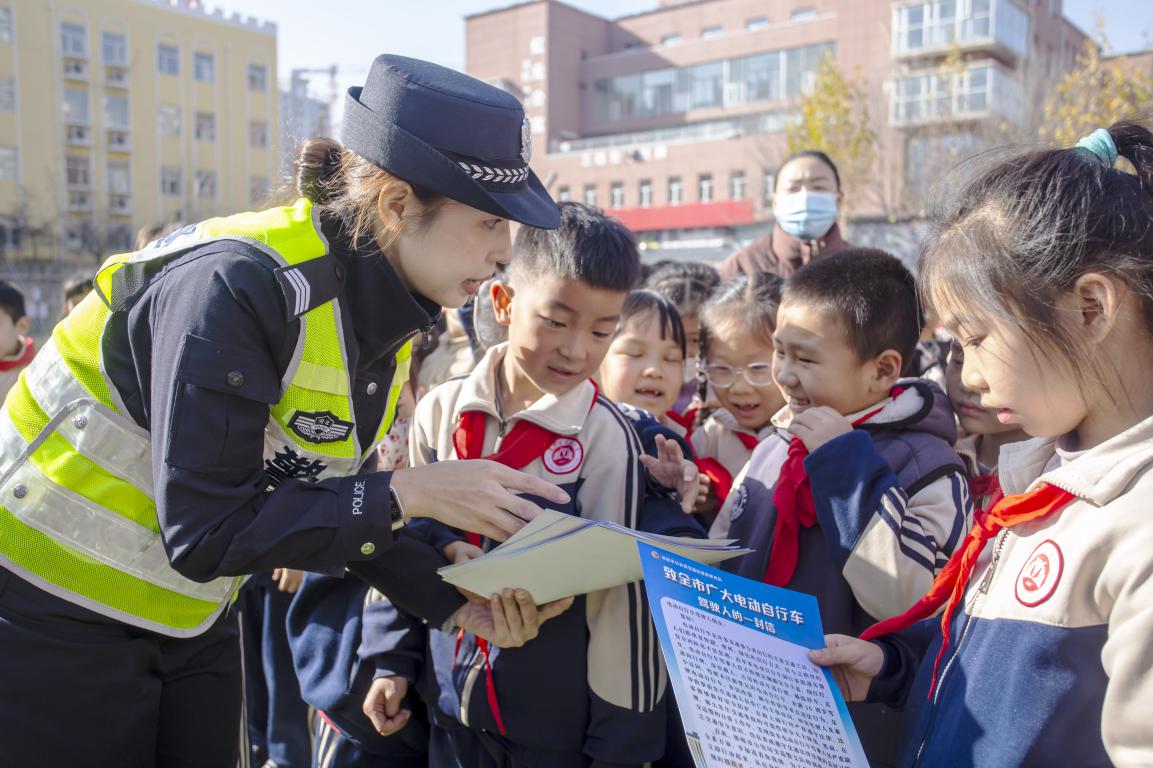 11月26日，河北省邯郸市复兴区实验小学操场，交警为孩子们发放交通安全宣传单。聂长青摄