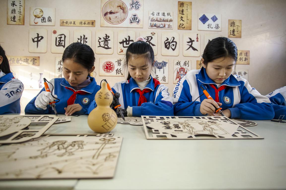 11月27日,河北省邯郸市复兴区时光小学的孩子们在老师指导下,通过剪纸、衍纸、烙画技艺等学习交通安全知识。聂长青摄