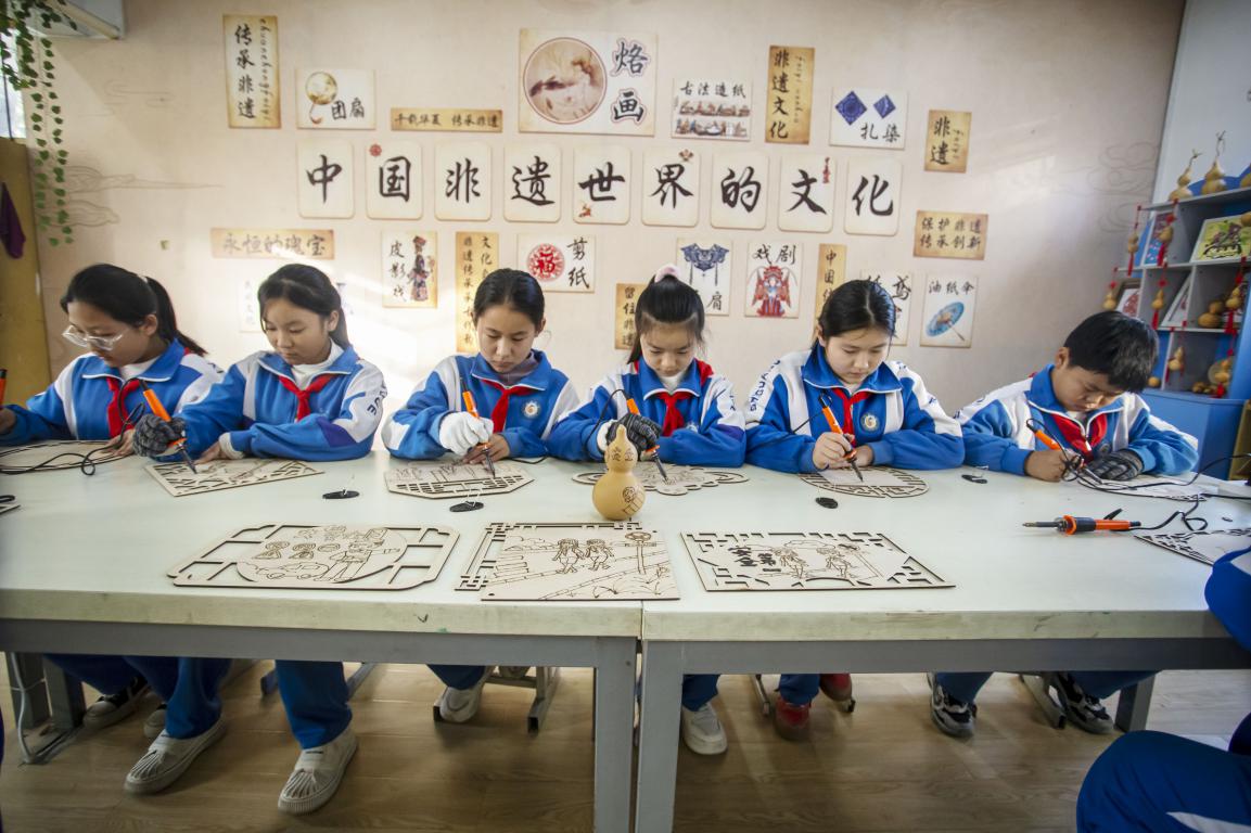 11月27日,河北省邯郸市复兴区时光小学的孩子们在老师指导下,通过剪纸、衍纸、烙画技艺等学习交通安全知识。聂长青摄