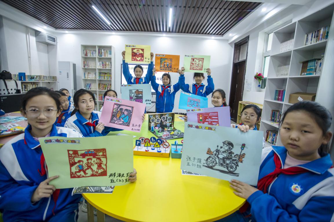 11月27日,河北省邯郸市复兴区时光小学的孩子们在老师指导下,通过剪纸、衍纸、烙画技艺等学习交通安全知识。聂长青摄