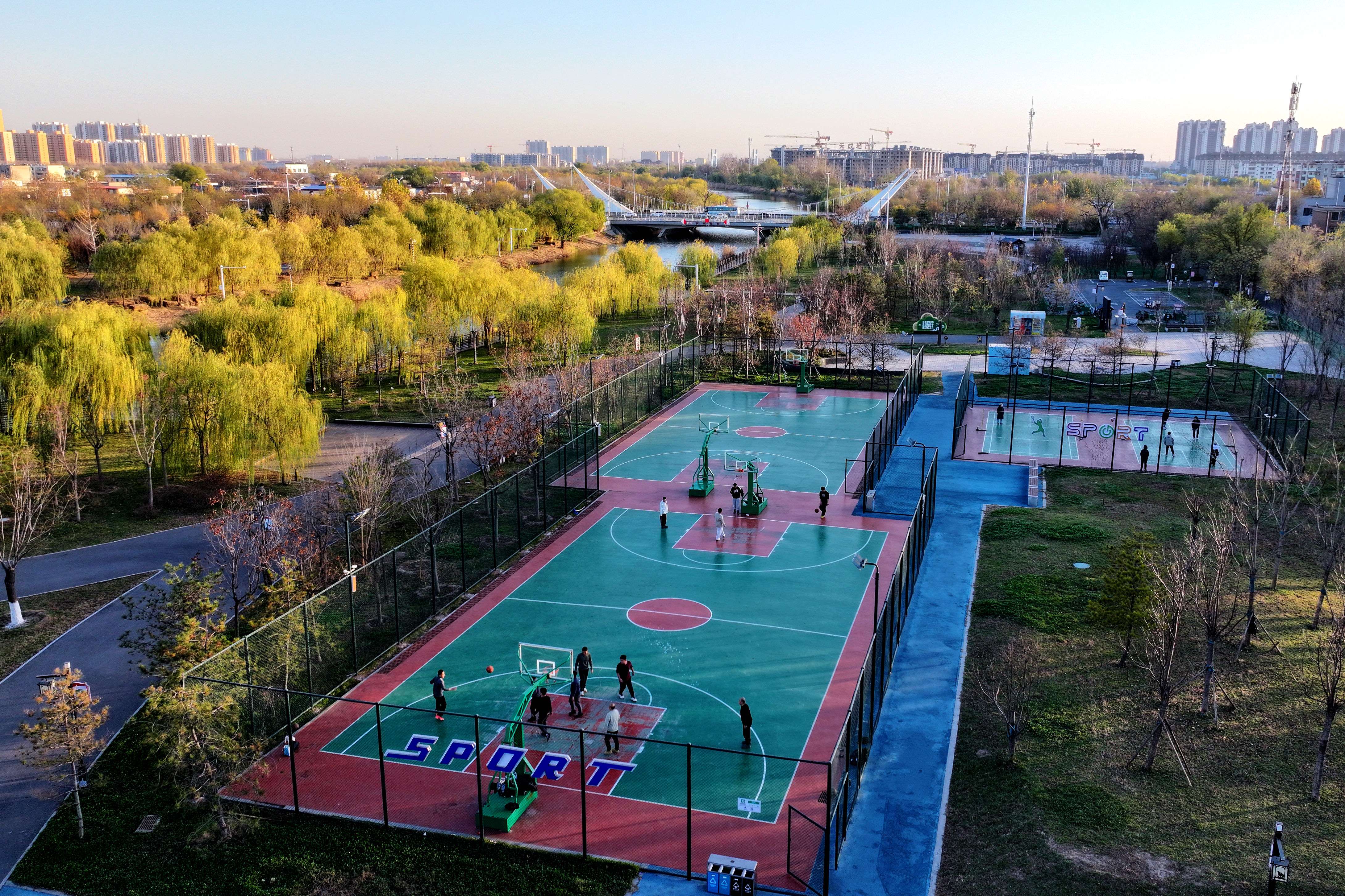 市民在大运河畔篮球场内运动。赵雪聪摄