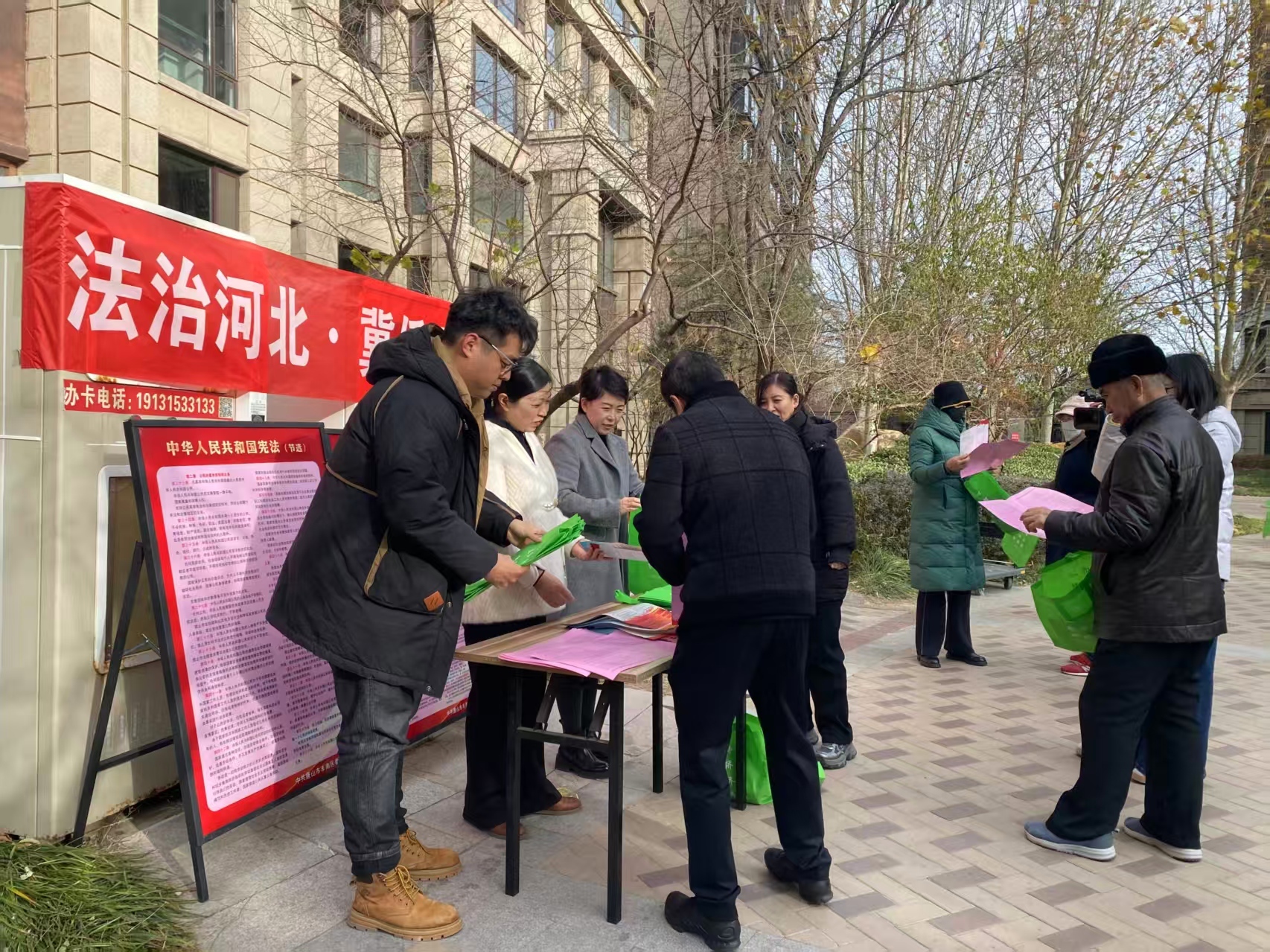 工作人員擺放法制宣傳展牌，發放宣傳資料。景愷攝