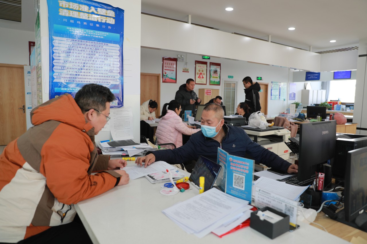 工作人員指導公司負責人辦理企業股權變更業務。趙端攝