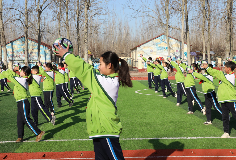 12月4日，小学生在操场上演练足球操。刘金忠摄