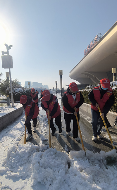 青年志愿者在石家庄站前广场清理冰雪。共青团河北省委供图