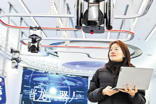 12月15日,雄安科创中心中试基地,北京普龙科技有限公司工作人员对挂轨式AI巡检机器人进行测试。 本报记者 刘光昱摄