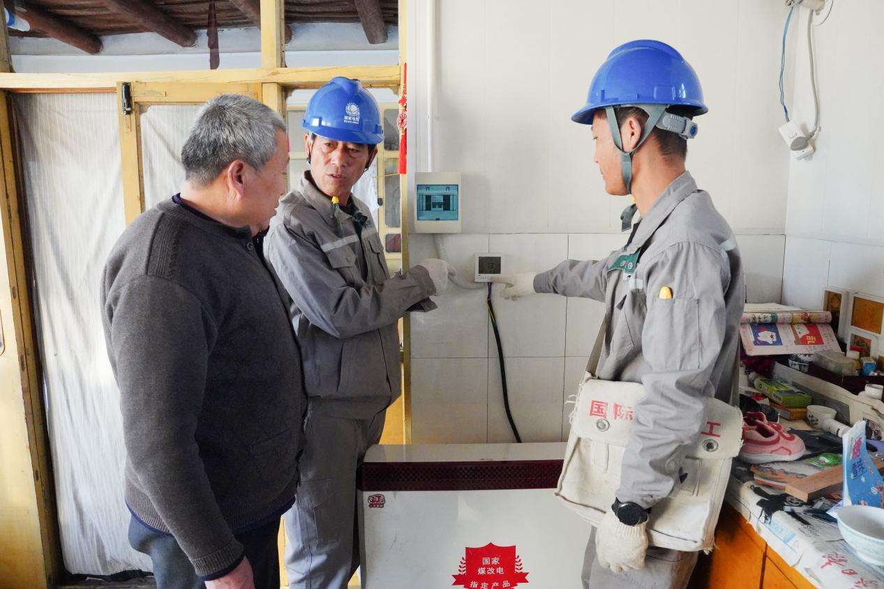 丰南电力公司员工在东田庄镇王打刁村村民家中检查电采暖智能开关运行情况。荣华摄