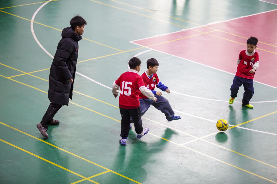 12月19日,河北省邯郸市复兴区美好小学校园内,孩子们在“河北五超”队员的指导下开展足球基本功训练。聂长青摄