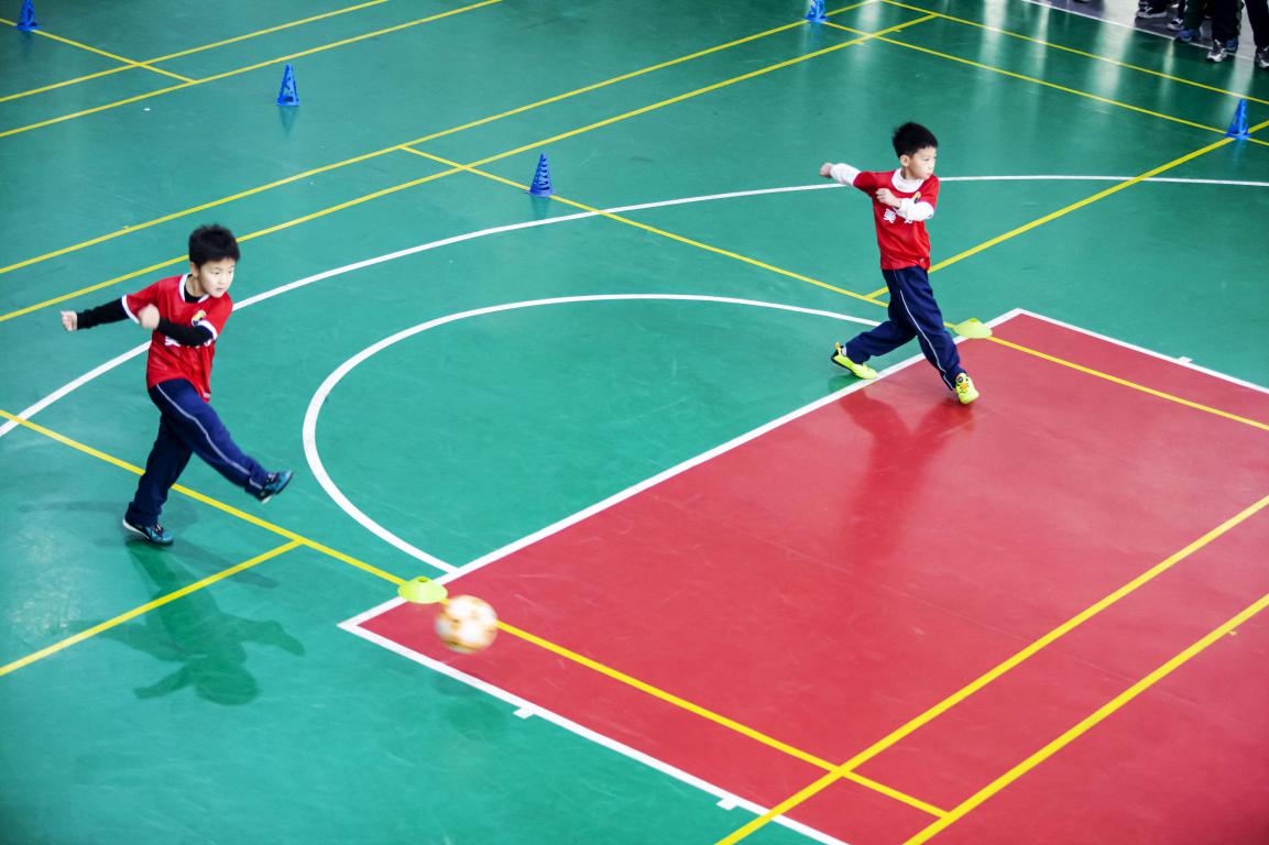 12月19日,河北省邯郸市复兴区美好小学校园内,孩子们在“河北五超”队员的指导下开展足球基本功训练。聂长青摄