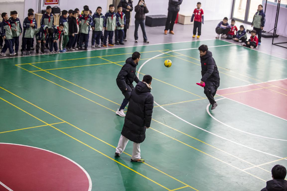 12月19日，河北省邯郸市复兴区美好小学校园内，“河北五超”队员为孩子们展示足球的盘带技巧。聂长青摄