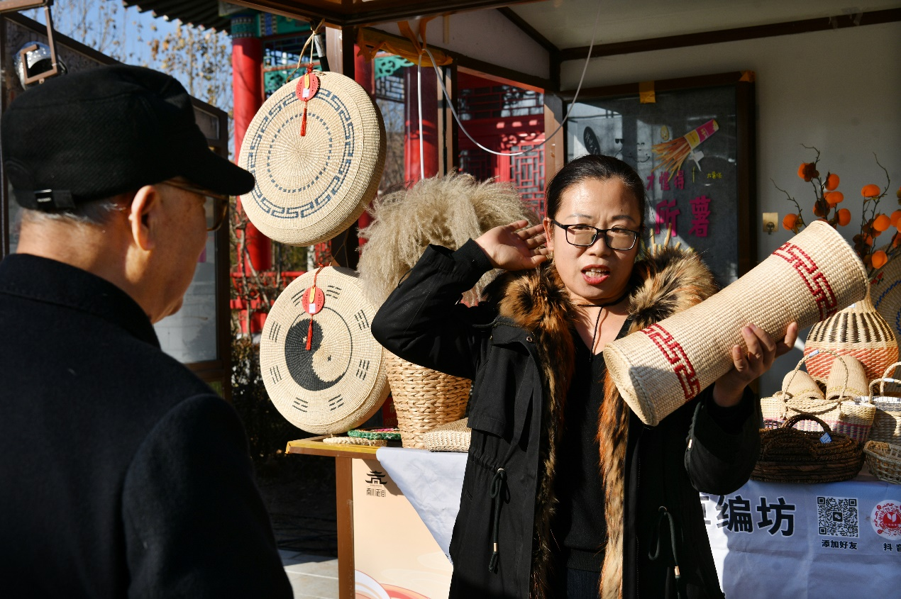 12月21日，草編藝人在民俗主題市集上向游客介紹草編制品。苑立偉攝
