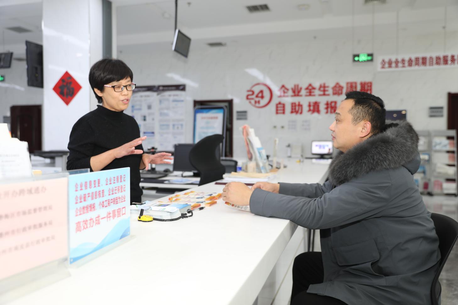 工作人员向企业负责人介绍惠企政策。靳东凯摄