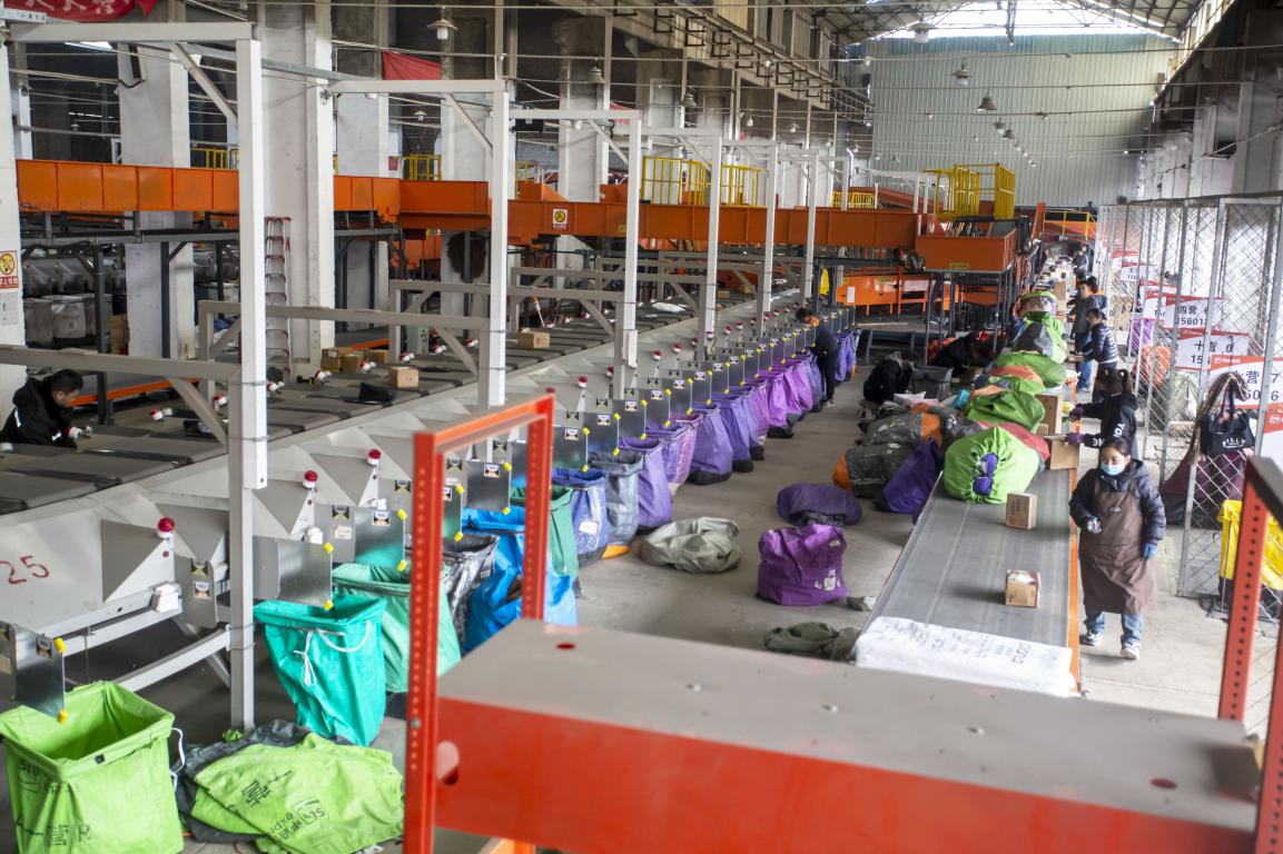 12月23日，河北省邯郸市复兴区一家快递集散中心，工人在智能化分拣线上分拣快递包裹。聂长青摄