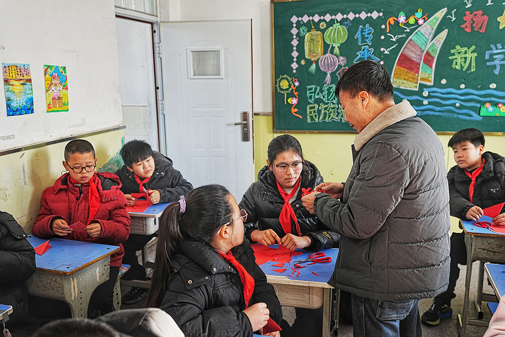 12月25日,非物质文化遗产代表性传承人正在一对一指导学生剪纸。张泽慧摄