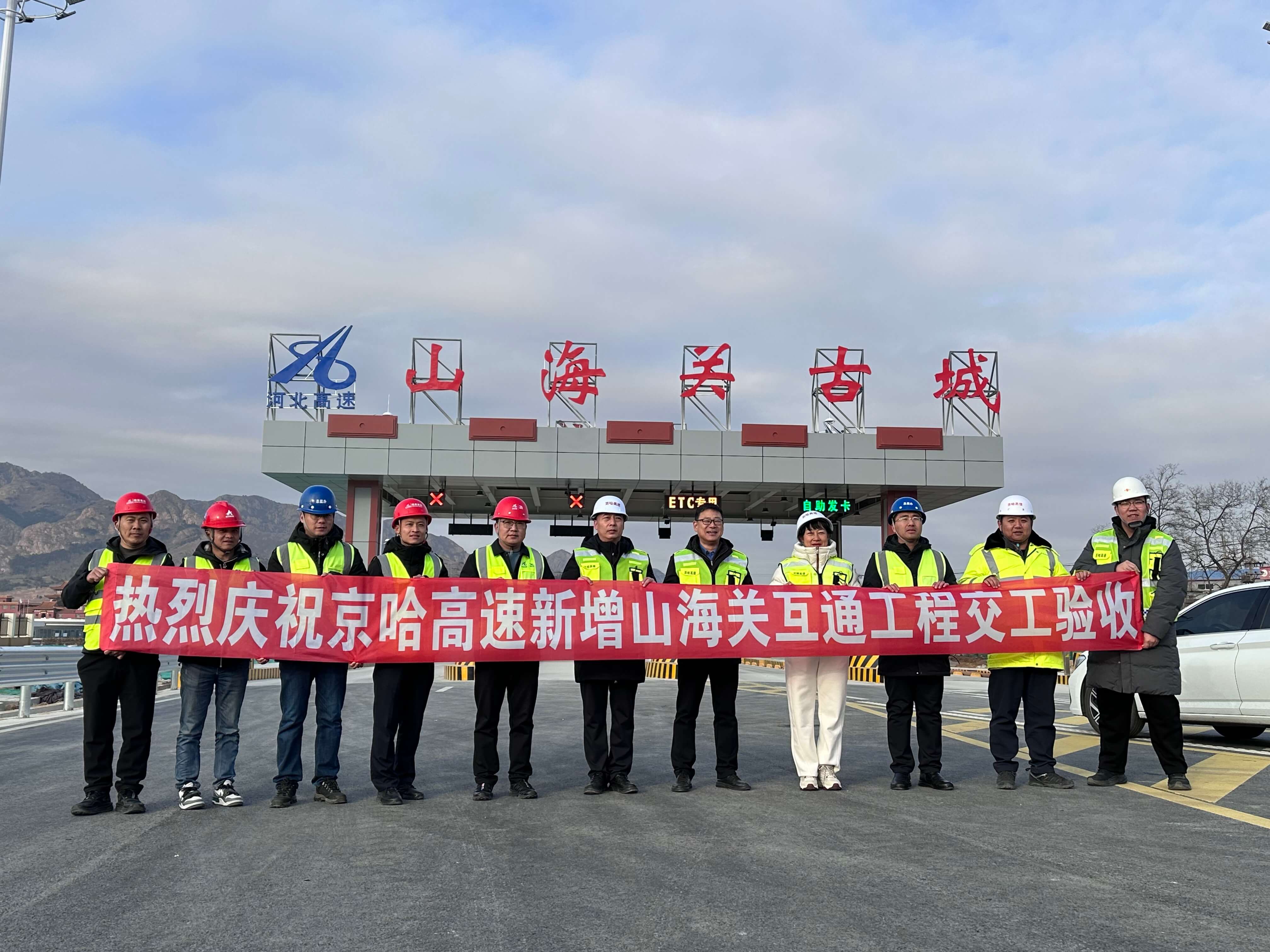 京哈高速公路新增山海关互通工程顺利通过交工验收,参建人员在“山海关古城” 收费站前合影留念。岳红波摄