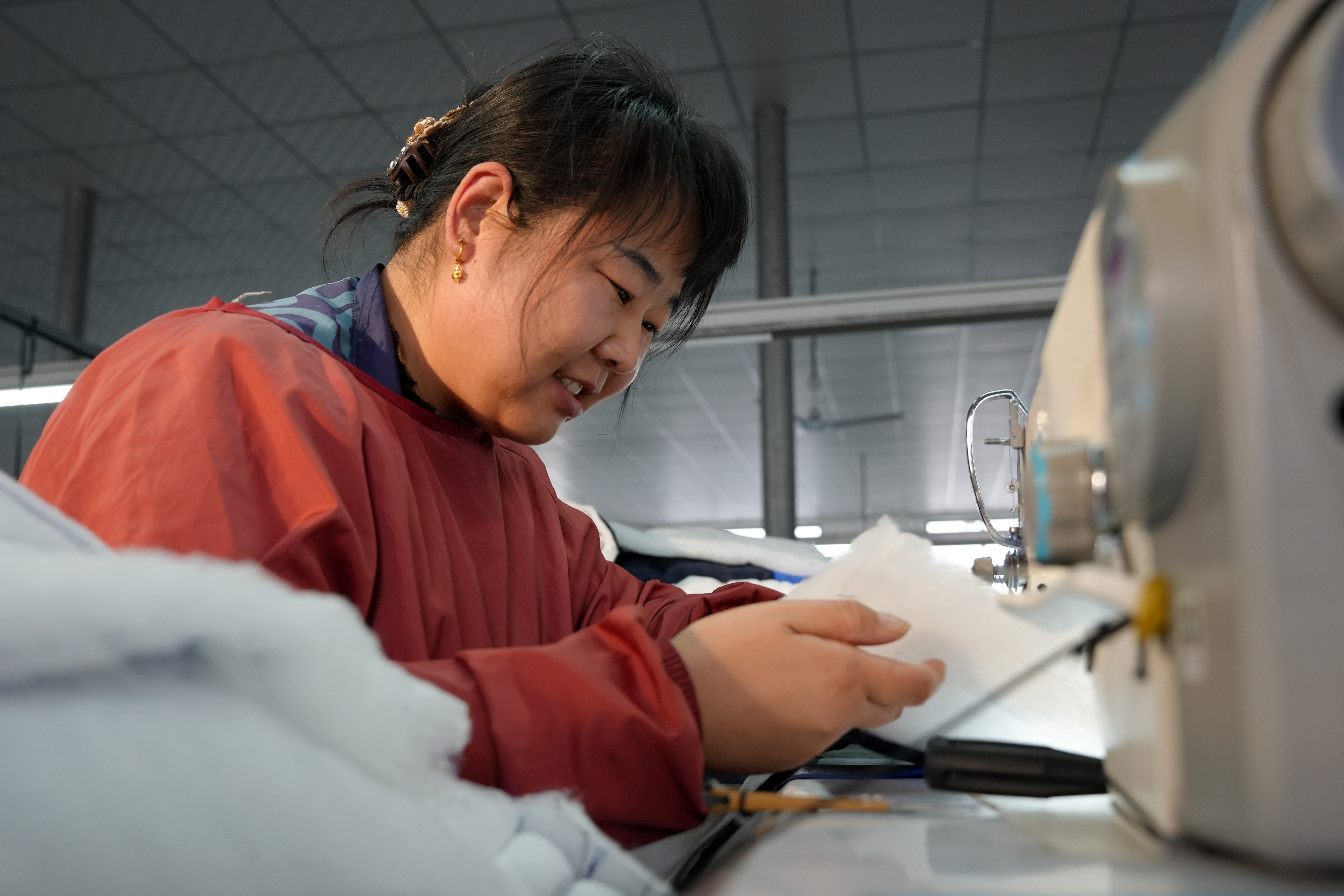 12月26日,云霞制衣的工人正在缝制衣服。王雪摄