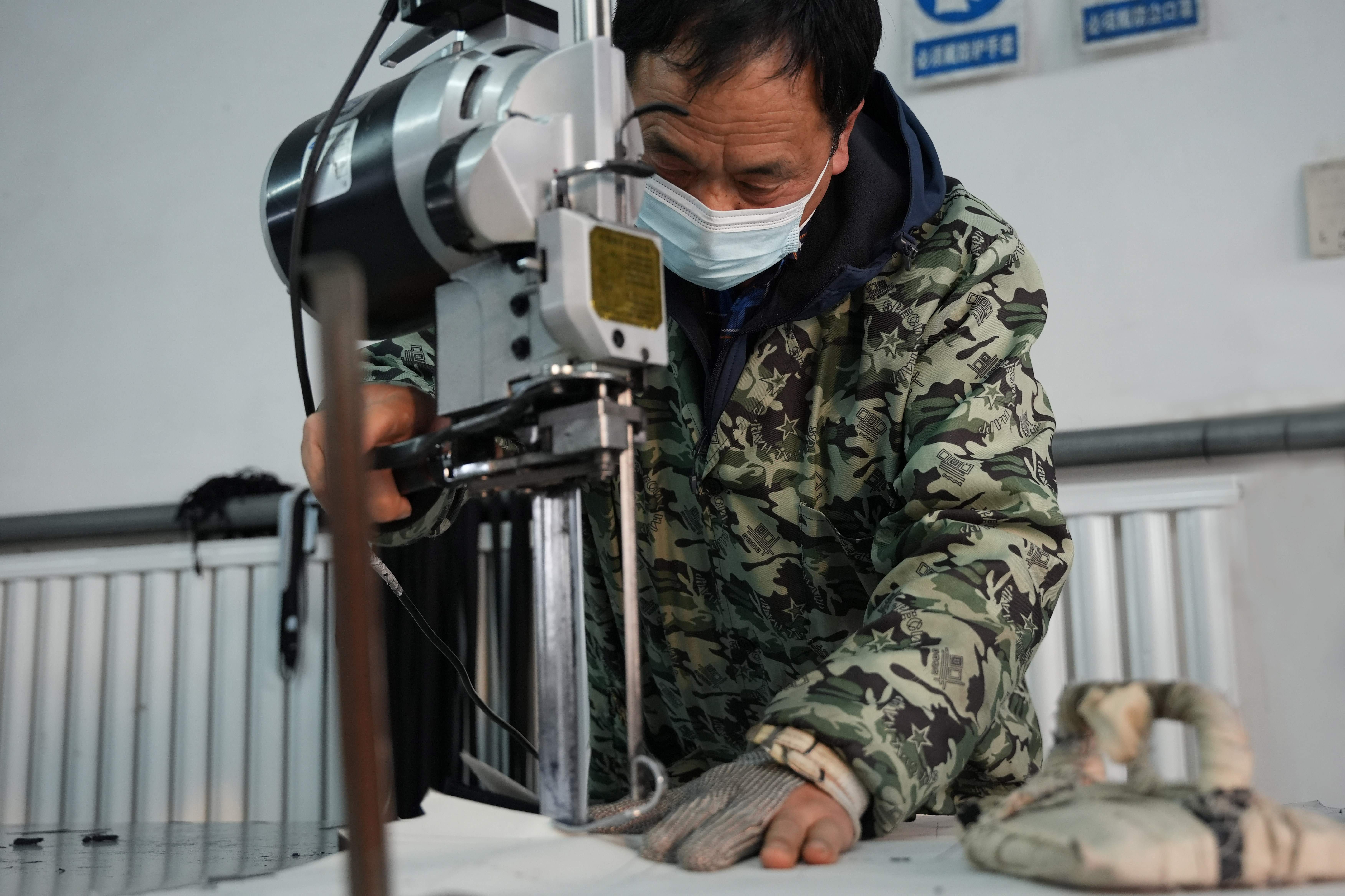 12月26日,云霞制衣的工人正在裁切布料。王雪摄