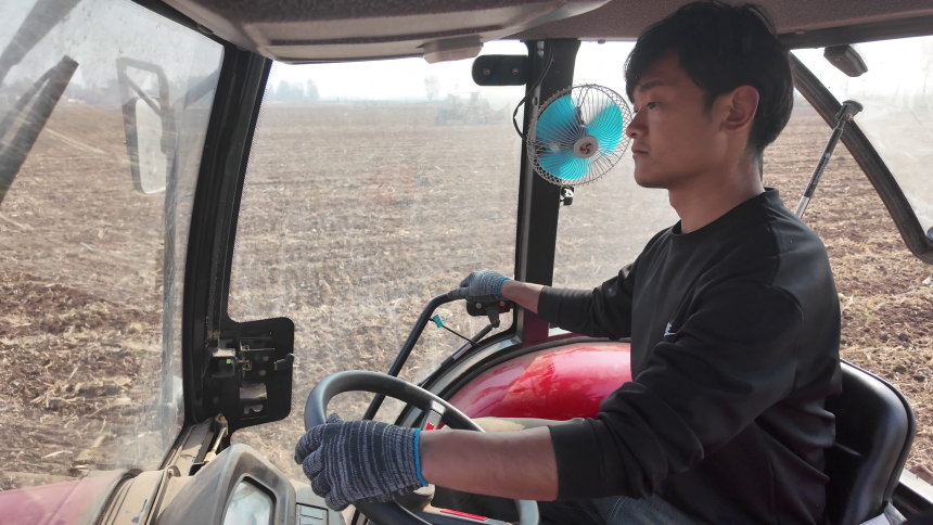 武志強駕駛農機在田間耕作。潘高佔攝