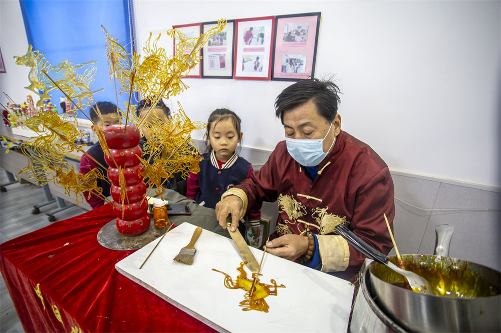 孩子们学习吹糖画。聂长青摄