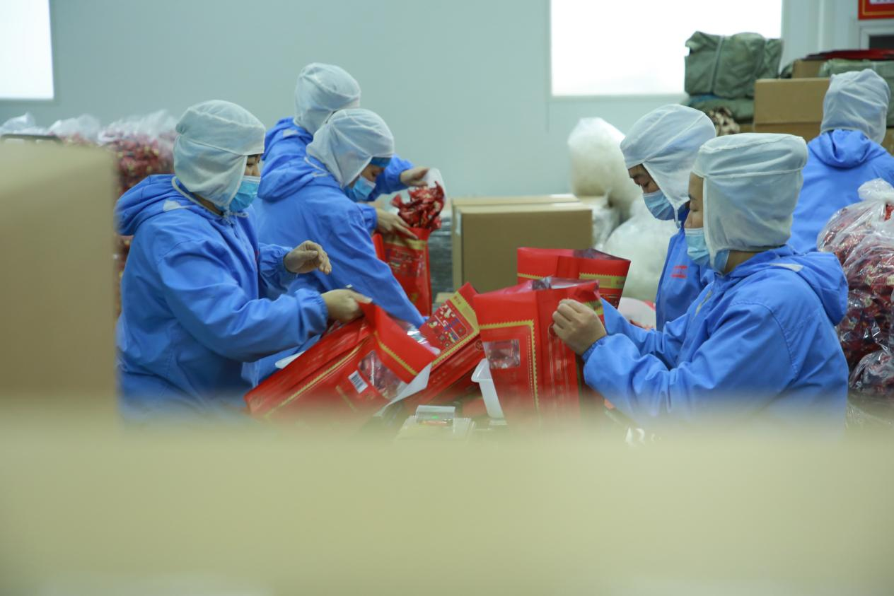 在外包车间，工人们正在忙碌工作。殷实摄