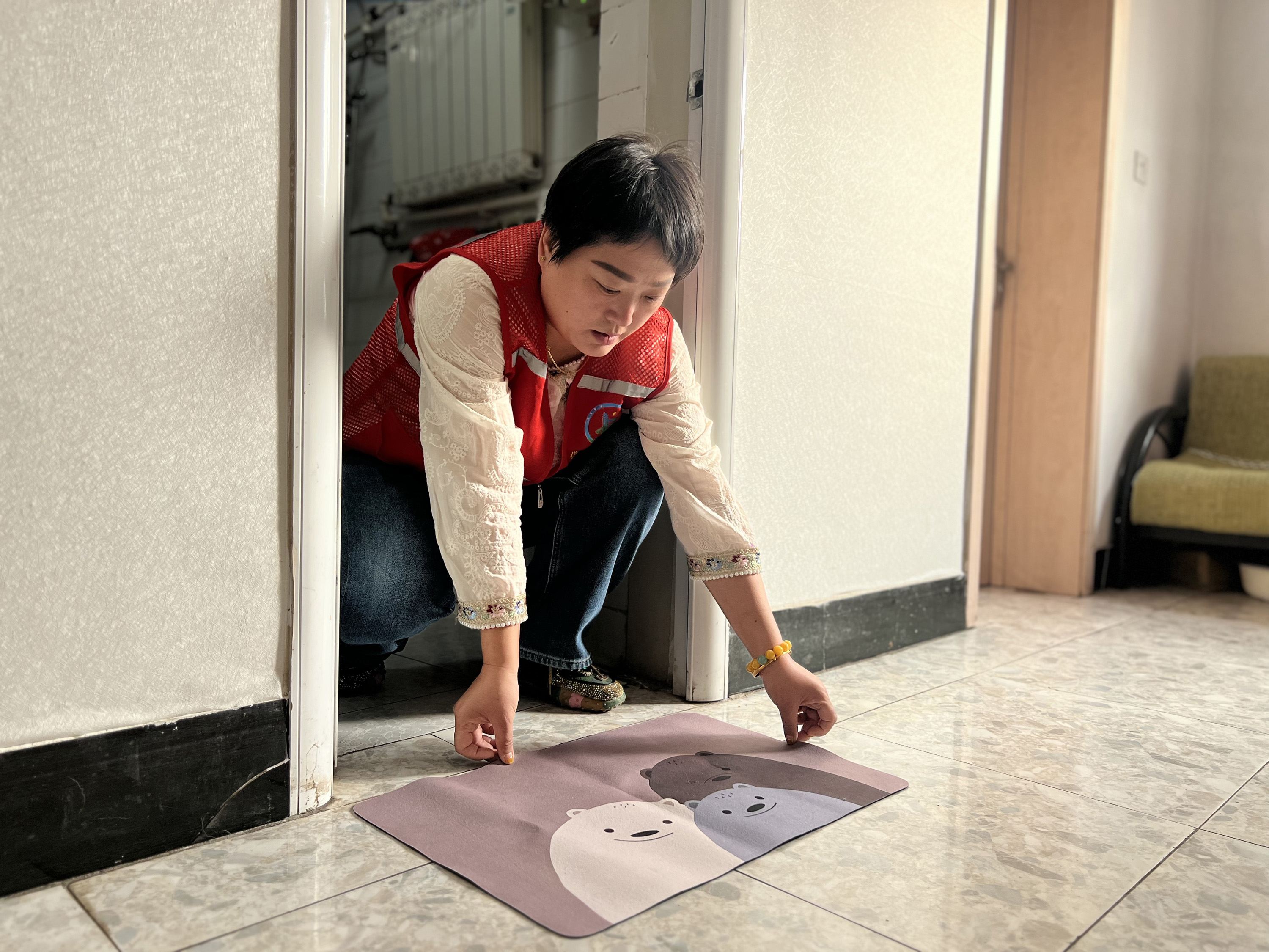 1月16日,鑽石社區“社區應急響應第一人”首批學員李嫣嫣在老人家中鋪設防滑墊。母東瑩攝