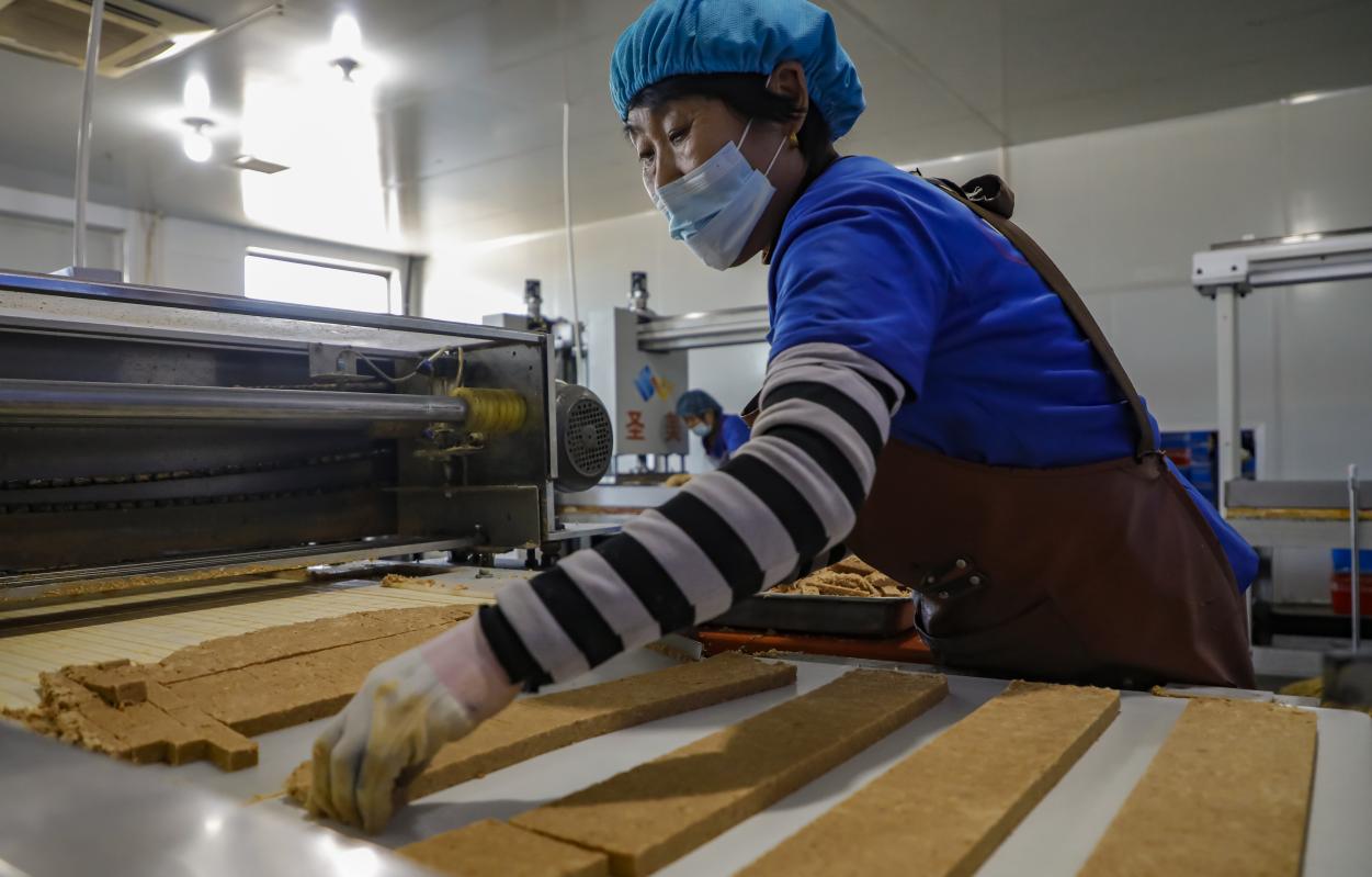 丰南区小集镇一家食品企业的生产车间内，工人正在制作花生酥糖。陈军摄