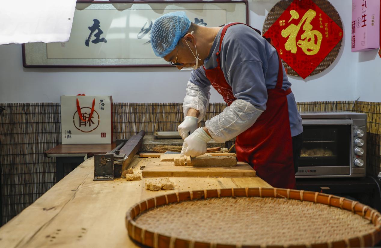 丰南一家食品企业负责人正在展示手工制作酥糖工艺。陈军摄