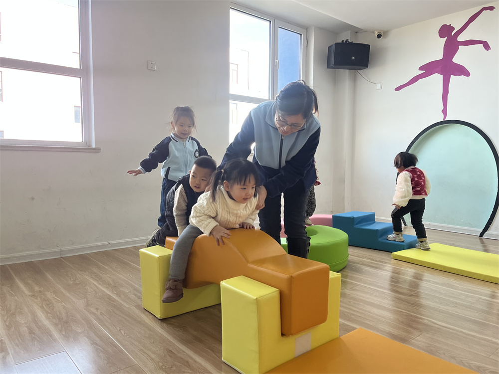 幼兒園老師輔導孩子利用感統器材訓練。郭強攝