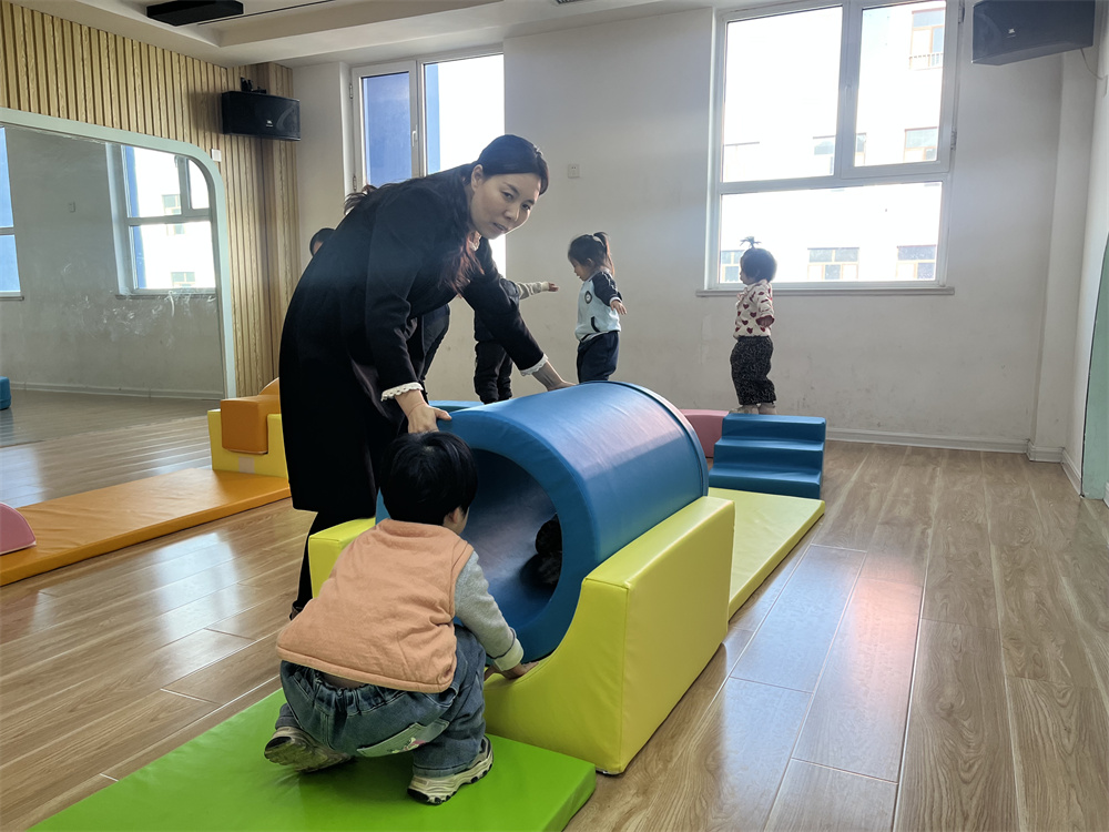 幼兒園老師輔導孩子利用感統器材訓練。郭強攝