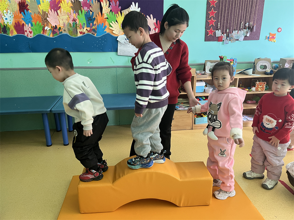 幼兒園老師輔導孩子利用感統器材訓練。郭強攝