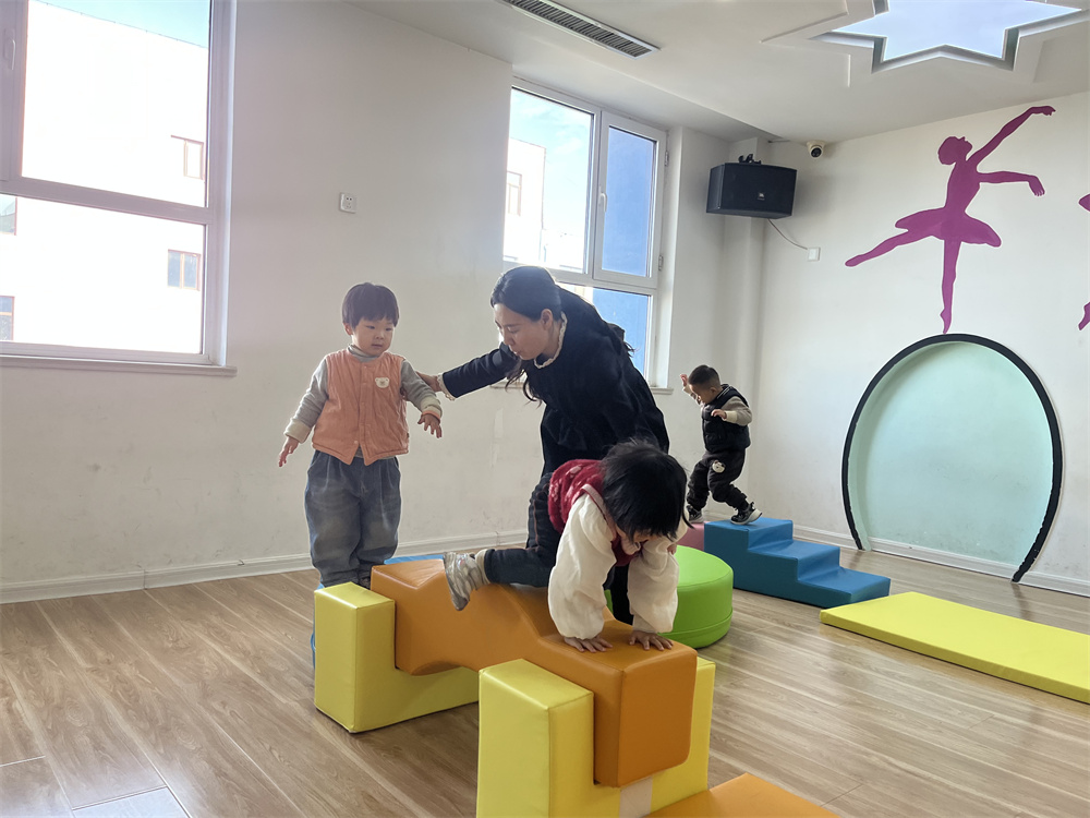 幼兒園老師輔導孩子利用感統器材訓練。郭強攝