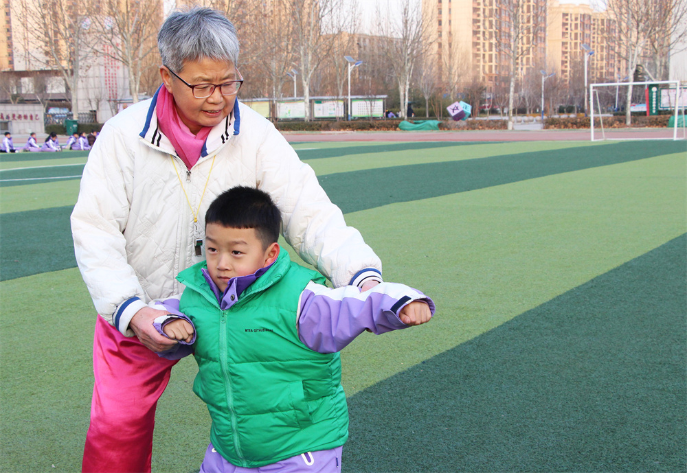 1月21日,在高阳县西街小学操场,常敏杰老师手把手教孩子学习武术。杨瀰摄