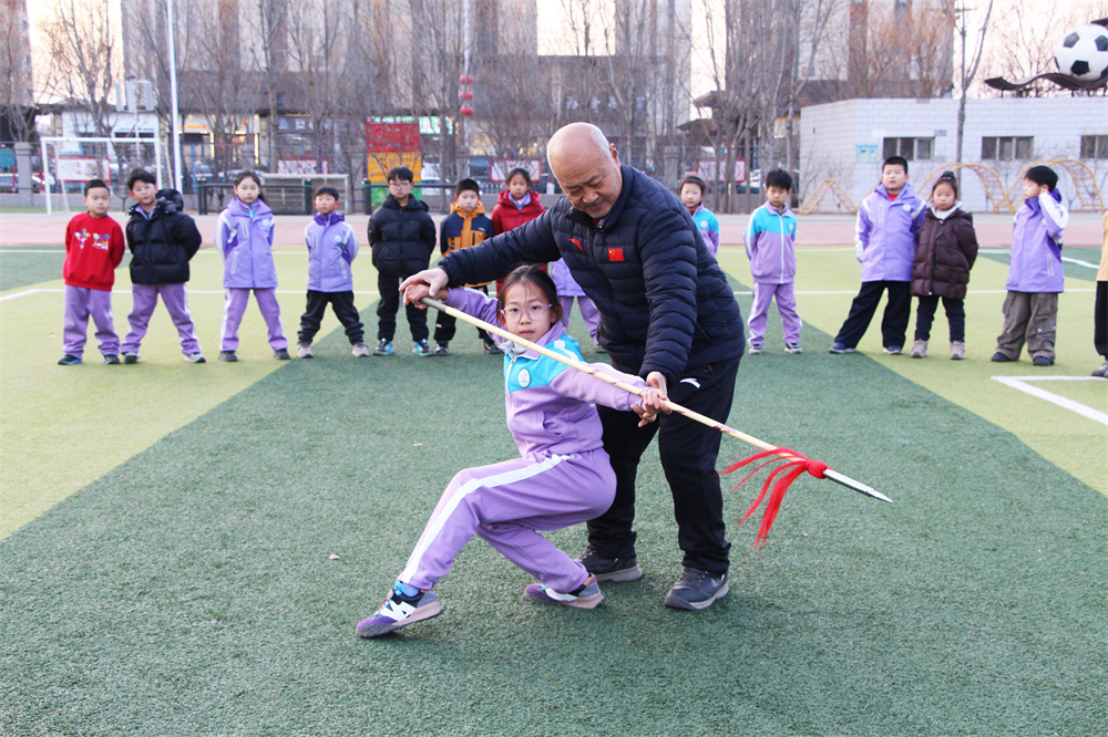 1月21日，在高阳县西街小学操场，周彦老师手把手指导学生学习武术。杨瀰摄