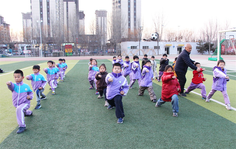 1月21日，在高阳县西街小学操场，周彦老师手把手指导学生学习武术。杨瀰摄