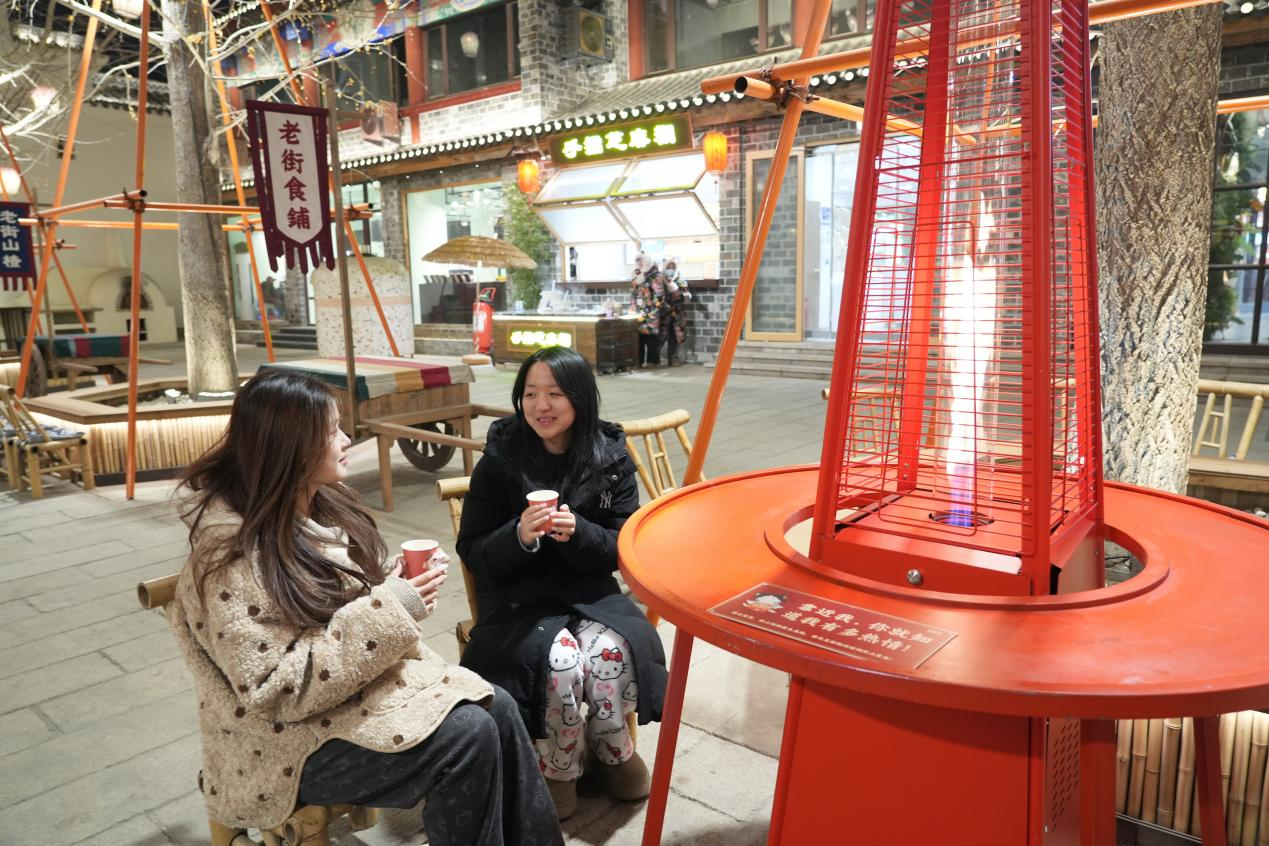 游客围座在“暖心火炉”旁享受惬意时光。陈军摄