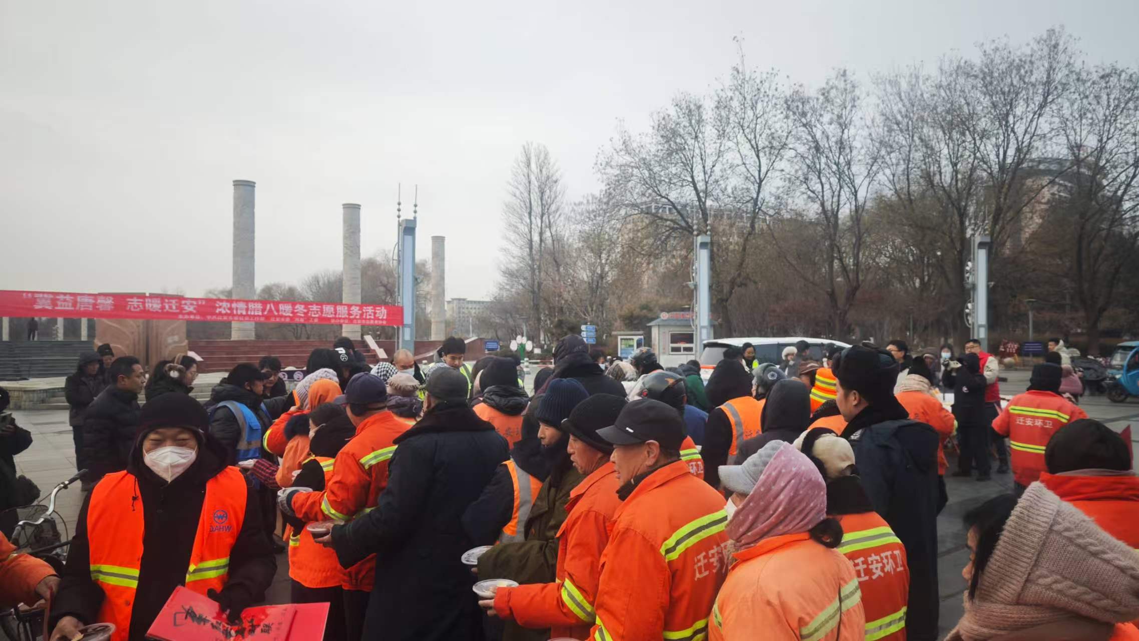 在迁安市人民广场，志愿者为户劳动者送来热腾腾的腊八粥。郭强摄