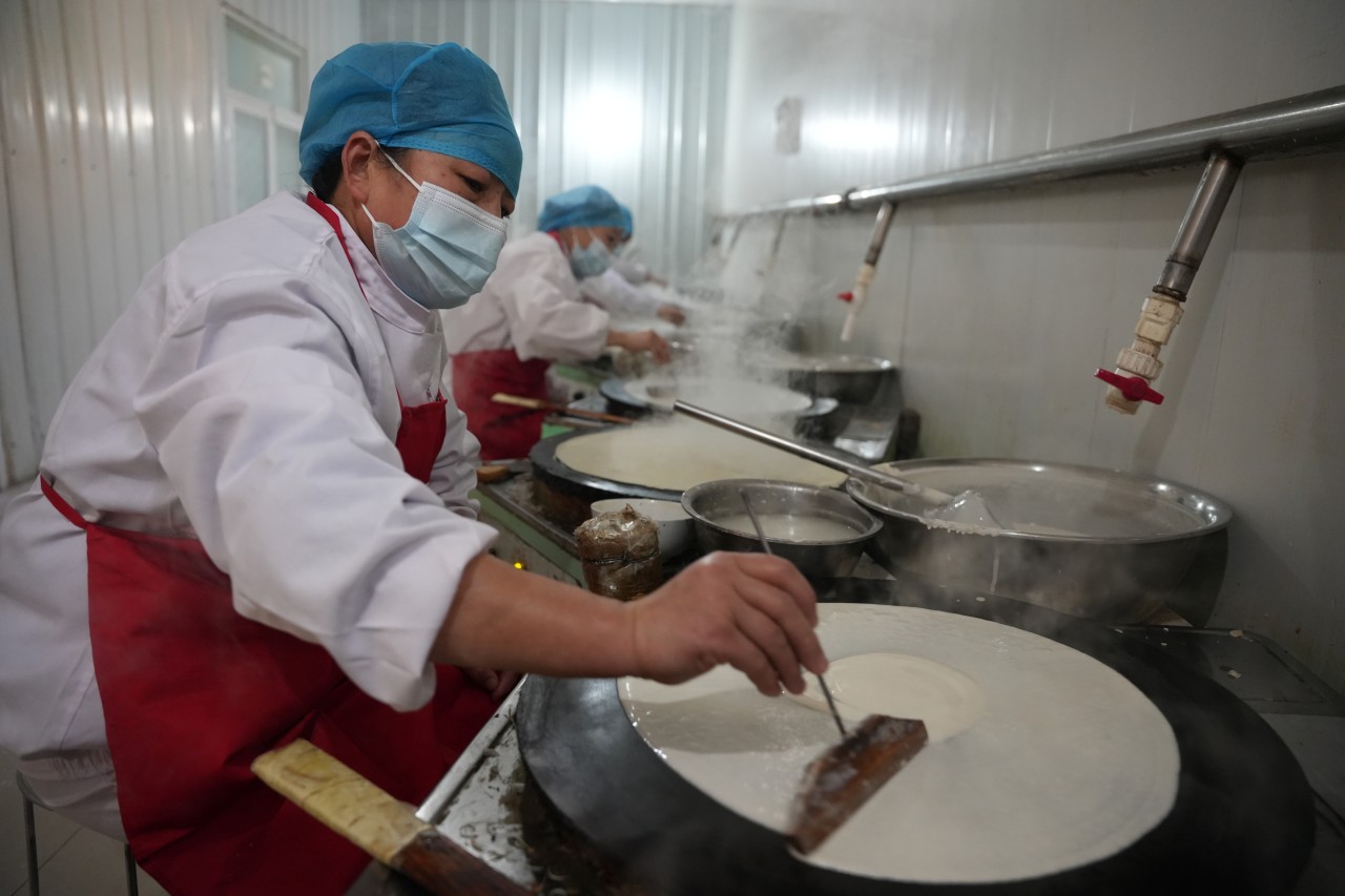 1月25日，河北省隆尧县隆尧镇丘底村素叠子加工坊内，工人正在摊煎饼。王雪摄