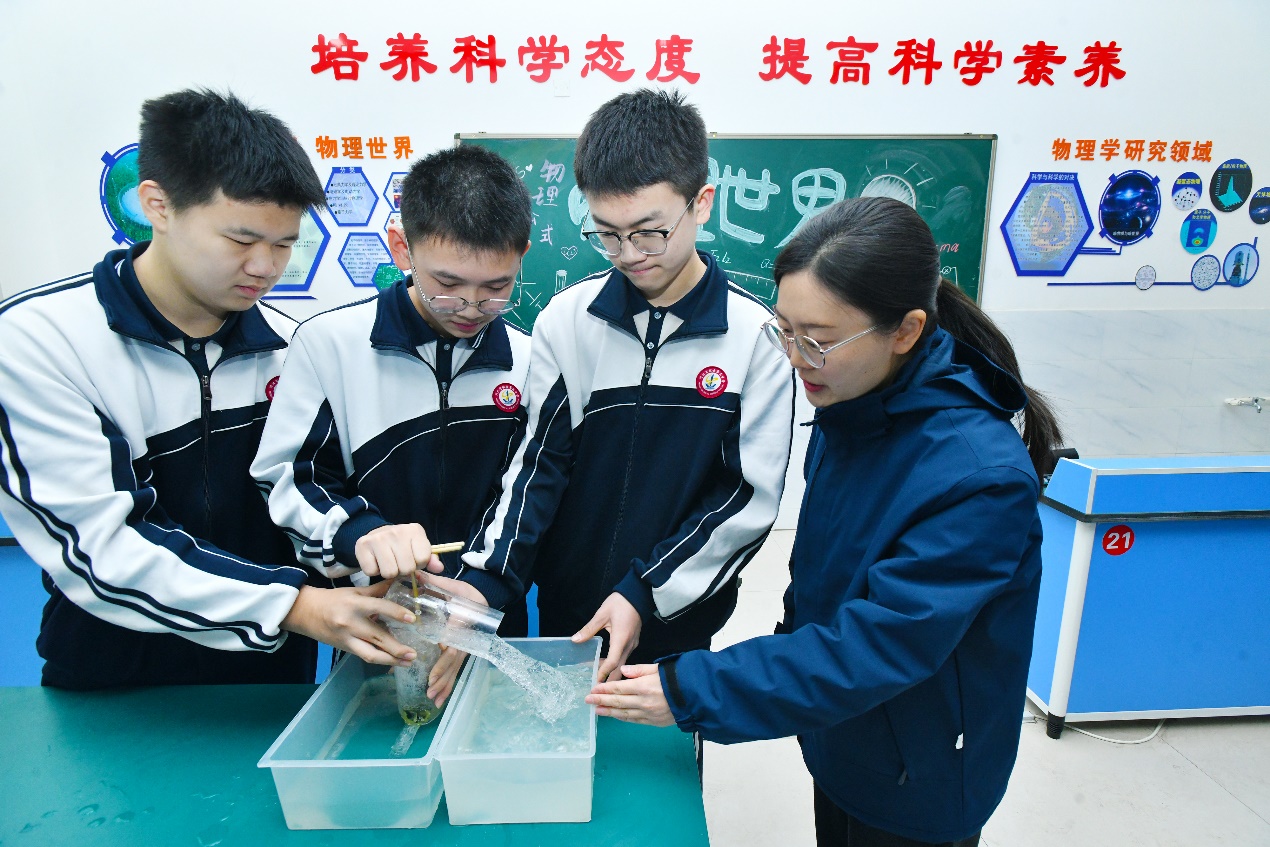 在献县第五中学，指导老师（右）与学生测试制作的活塞式抽水机。苑立伟摄