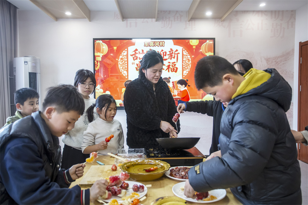 2月3日,河北省邯鄲市復興區二六七二街道東高河村,志願者與孩子們一起制作糖葫蘆。聶長青攝