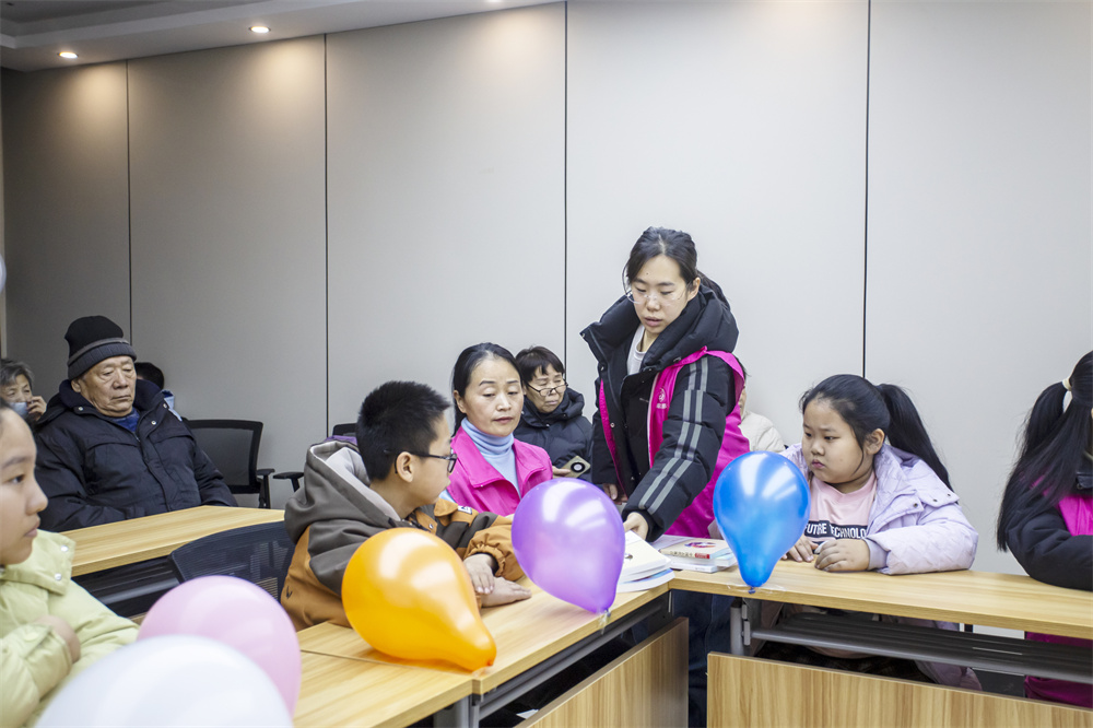 2月5日，河北省邯郸市复兴区庞村街道邯钢路社区，巾帼志愿者为孩子们发放图书。聂长青摄