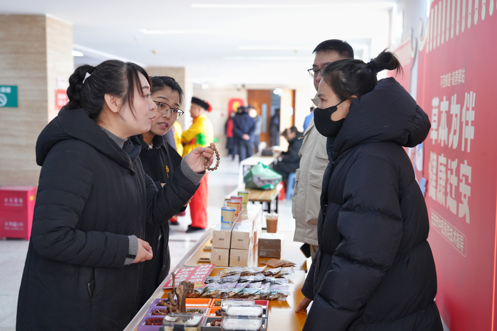 2月6日,迁安市民在“不苦邮差·轻养驿站”摊位前选购中药手串。张泽慧摄